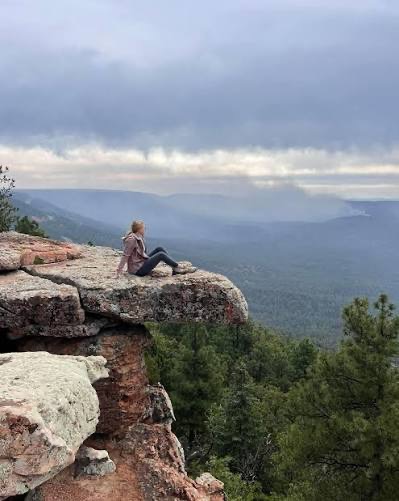 A visitor overlooking the forested mountains of Rim Country